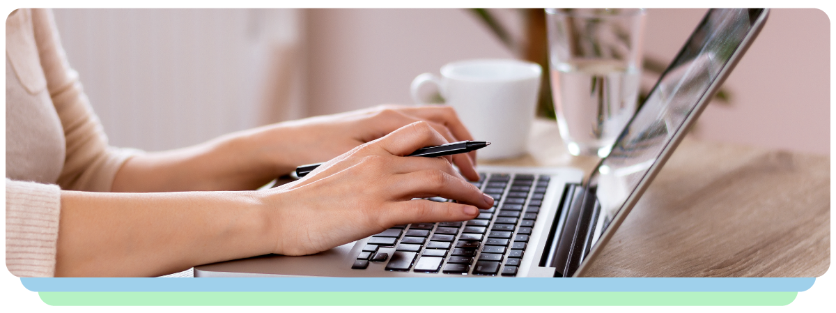 A Lady Holding Pen and also Typing on the Laptop